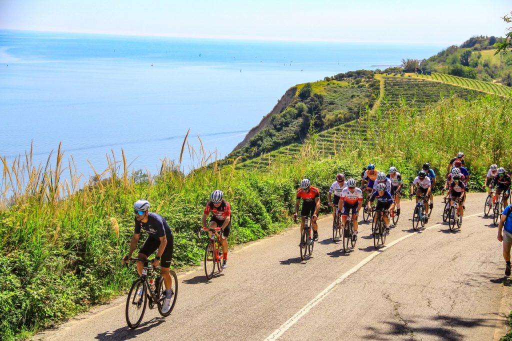 Ciclisti in azione sulla Panoramica del San Bartolo con vista spettacolare sul mare Adriatico durante la Granfondo Squali.