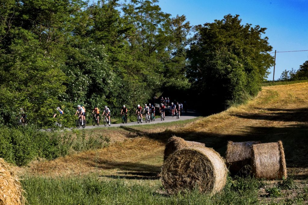 Passaggio della Granfondo Nove Colli tra campi con rotoloni di fieno